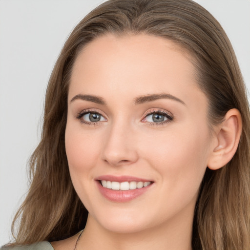 Joyful white young-adult female with long  brown hair and blue eyes