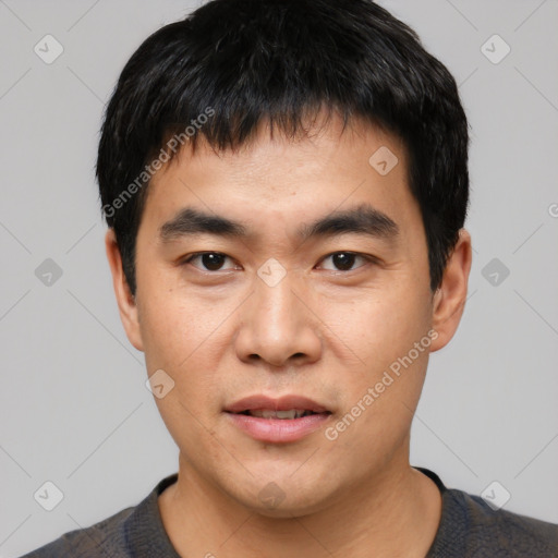 Joyful asian young-adult male with short  black hair and brown eyes