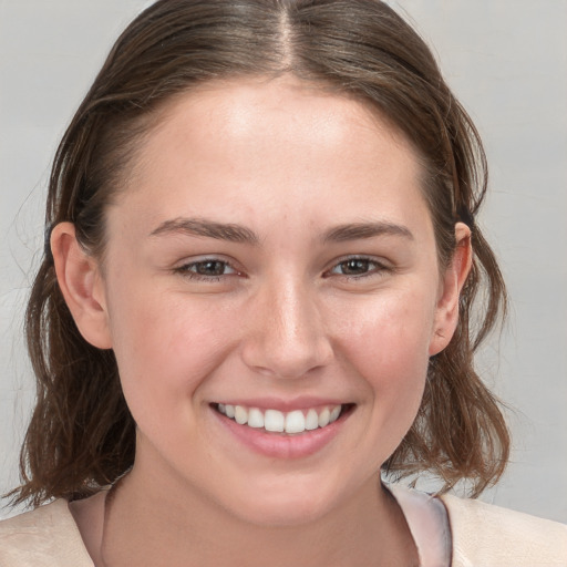 Joyful white young-adult female with medium  brown hair and grey eyes