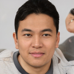 Joyful asian young-adult male with short  brown hair and brown eyes