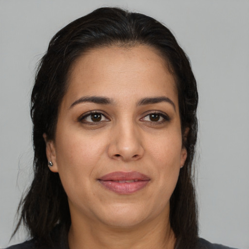 Joyful latino adult female with long  brown hair and brown eyes