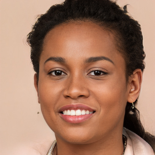 Joyful black young-adult female with long  brown hair and brown eyes