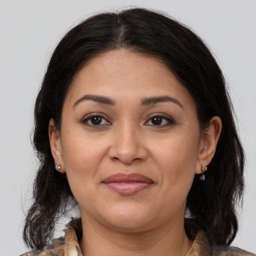 Joyful latino adult female with medium  brown hair and brown eyes