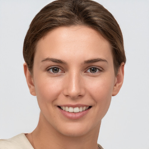 Joyful white young-adult female with short  brown hair and grey eyes