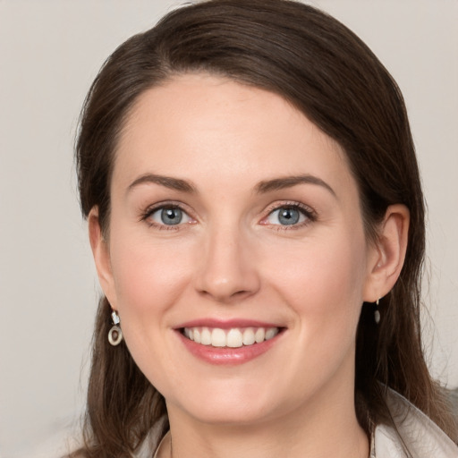 Joyful white young-adult female with long  brown hair and grey eyes