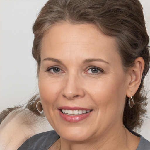 Joyful white adult female with medium  brown hair and brown eyes