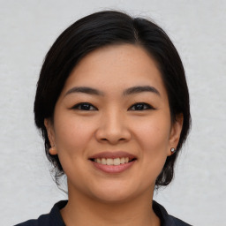 Joyful asian young-adult female with medium  black hair and brown eyes