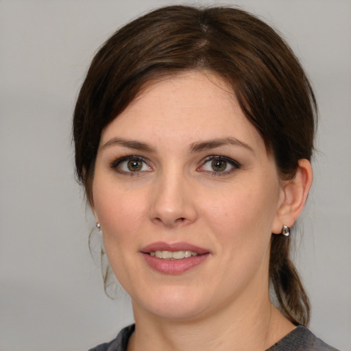 Joyful white young-adult female with medium  brown hair and green eyes