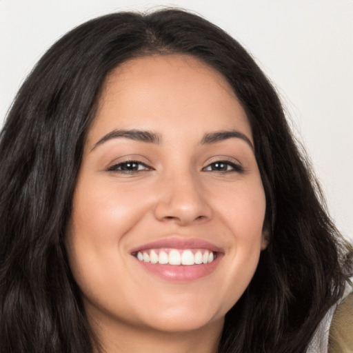 Joyful latino young-adult female with long  brown hair and brown eyes