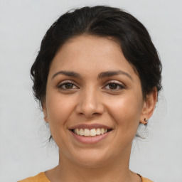 Joyful latino young-adult female with medium  brown hair and brown eyes