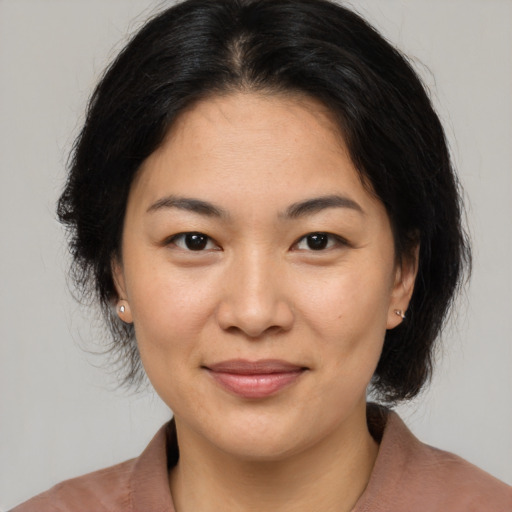 Joyful asian young-adult female with medium  brown hair and brown eyes