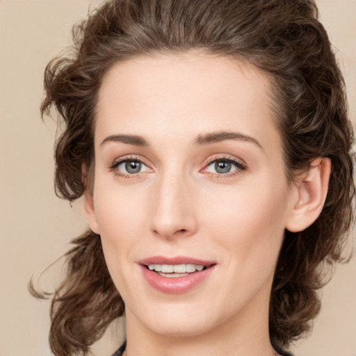 Joyful white young-adult female with medium  brown hair and green eyes