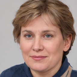 Joyful white adult female with medium  brown hair and blue eyes