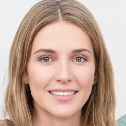 Joyful white young-adult female with long  brown hair and green eyes