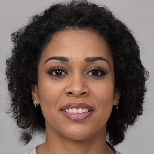Joyful black young-adult female with medium  brown hair and brown eyes