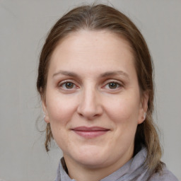 Joyful white young-adult female with medium  brown hair and grey eyes