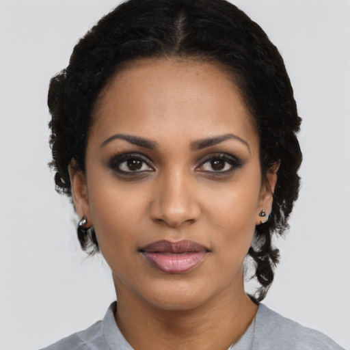Joyful black young-adult female with medium  black hair and brown eyes