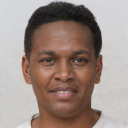 Joyful latino young-adult male with short  brown hair and brown eyes