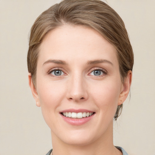 Joyful white young-adult female with short  brown hair and grey eyes