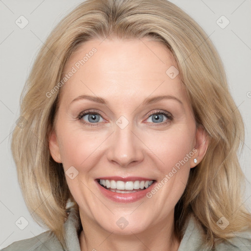 Joyful white adult female with medium  brown hair and blue eyes