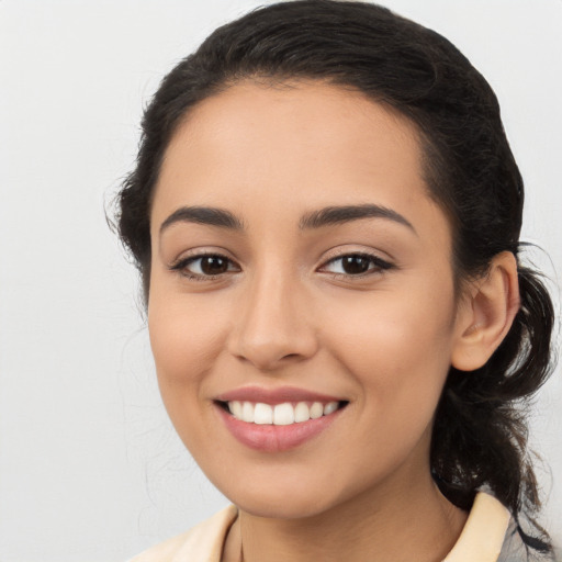 Joyful latino young-adult female with medium  brown hair and brown eyes