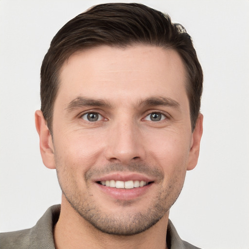 Joyful white young-adult male with short  brown hair and grey eyes