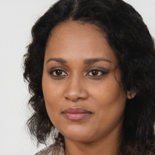 Joyful black young-adult female with long  brown hair and brown eyes