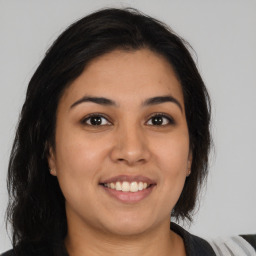 Joyful latino young-adult female with medium  brown hair and brown eyes