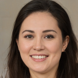 Joyful white young-adult female with long  brown hair and brown eyes