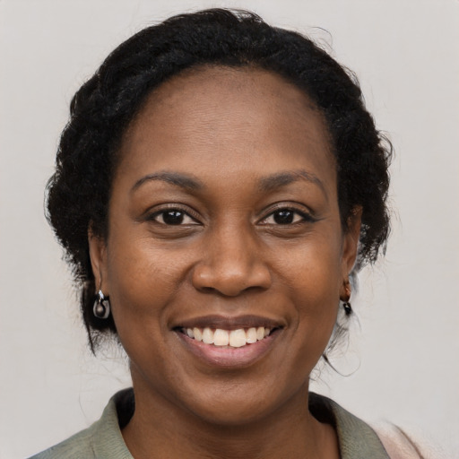 Joyful black adult female with medium  black hair and brown eyes