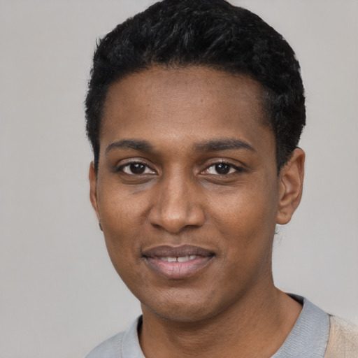 Joyful black young-adult male with short  black hair and brown eyes