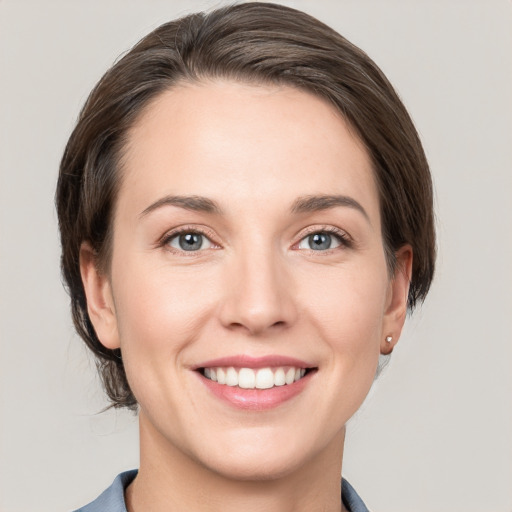 Joyful white young-adult female with short  brown hair and grey eyes