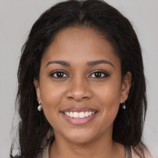 Joyful black young-adult female with long  brown hair and brown eyes