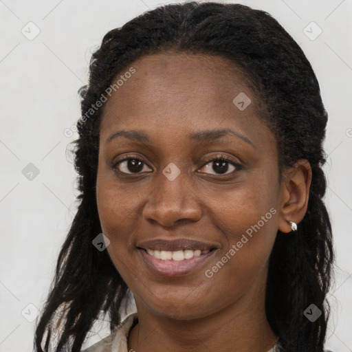 Joyful black young-adult female with long  brown hair and brown eyes