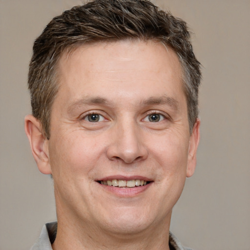 Joyful white adult male with short  brown hair and brown eyes