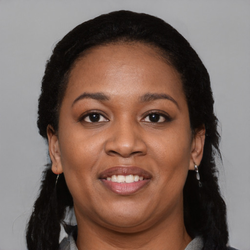 Joyful black young-adult female with long  black hair and brown eyes