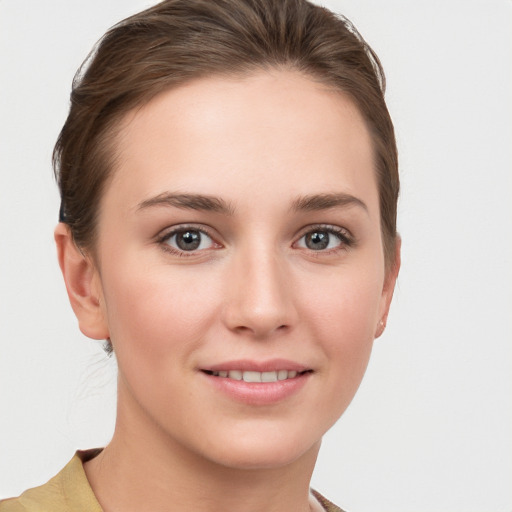 Joyful white young-adult female with short  brown hair and grey eyes