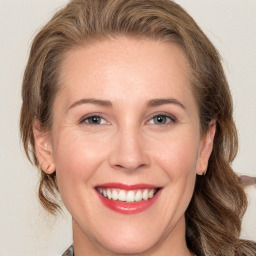 Joyful white adult female with medium  brown hair and grey eyes