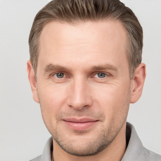 Joyful white adult male with short  brown hair and grey eyes