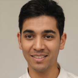 Joyful latino young-adult male with short  black hair and brown eyes