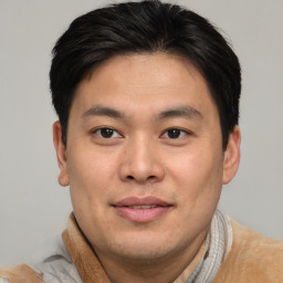 Joyful asian young-adult male with short  brown hair and brown eyes