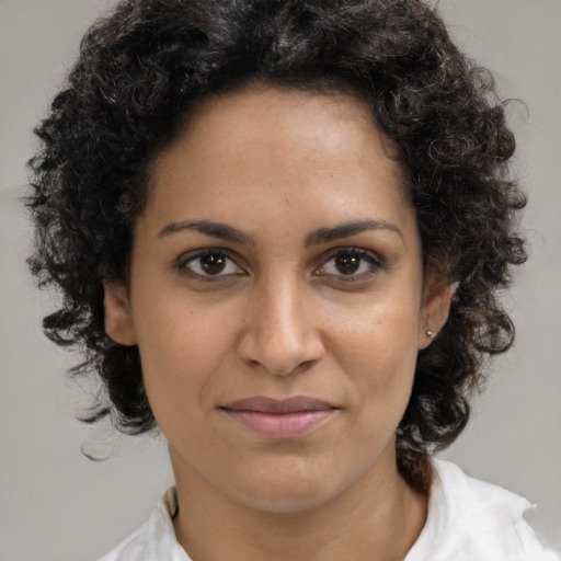 Joyful latino young-adult female with medium  brown hair and brown eyes