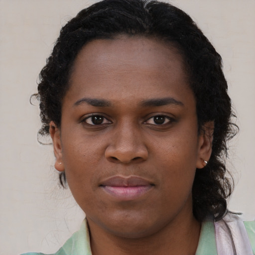 Joyful black young-adult female with long  brown hair and brown eyes