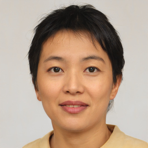 Joyful asian young-adult female with short  brown hair and brown eyes