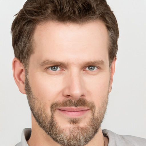 Joyful white adult male with short  brown hair and grey eyes