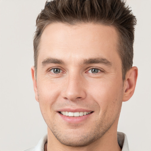 Joyful white young-adult male with short  brown hair and brown eyes