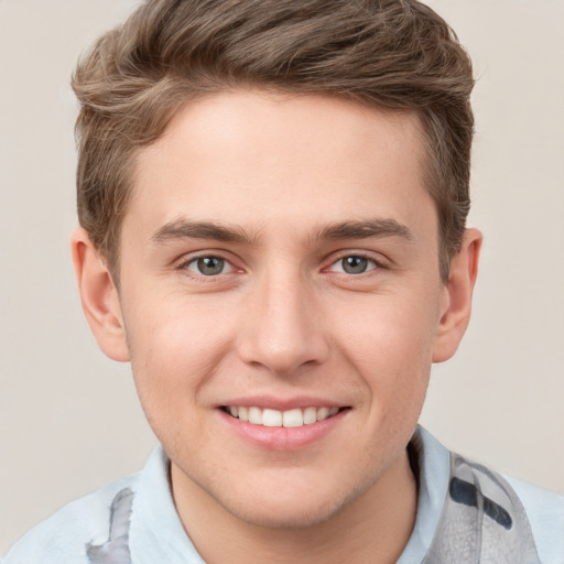 Joyful white young-adult male with short  brown hair and grey eyes