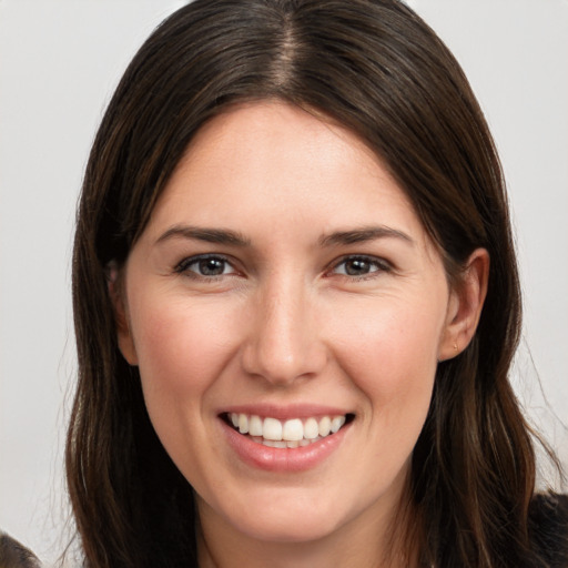 Joyful white young-adult female with long  brown hair and brown eyes