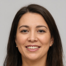 Joyful white young-adult female with long  brown hair and brown eyes