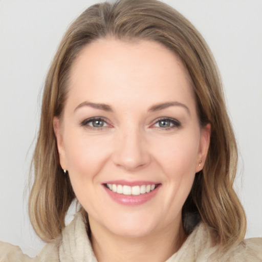 Joyful white young-adult female with medium  brown hair and grey eyes